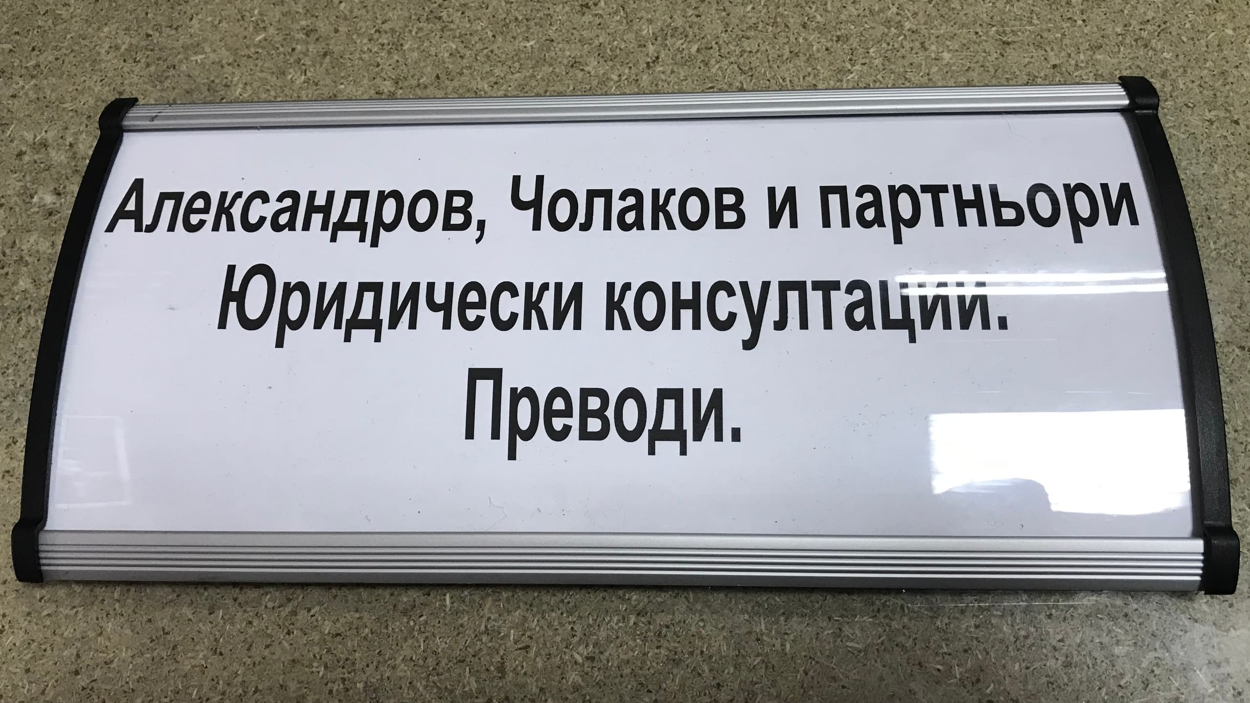 Информационна табела за офис от извит алуминиев профил с надпис за юридически консултации и преводи.
