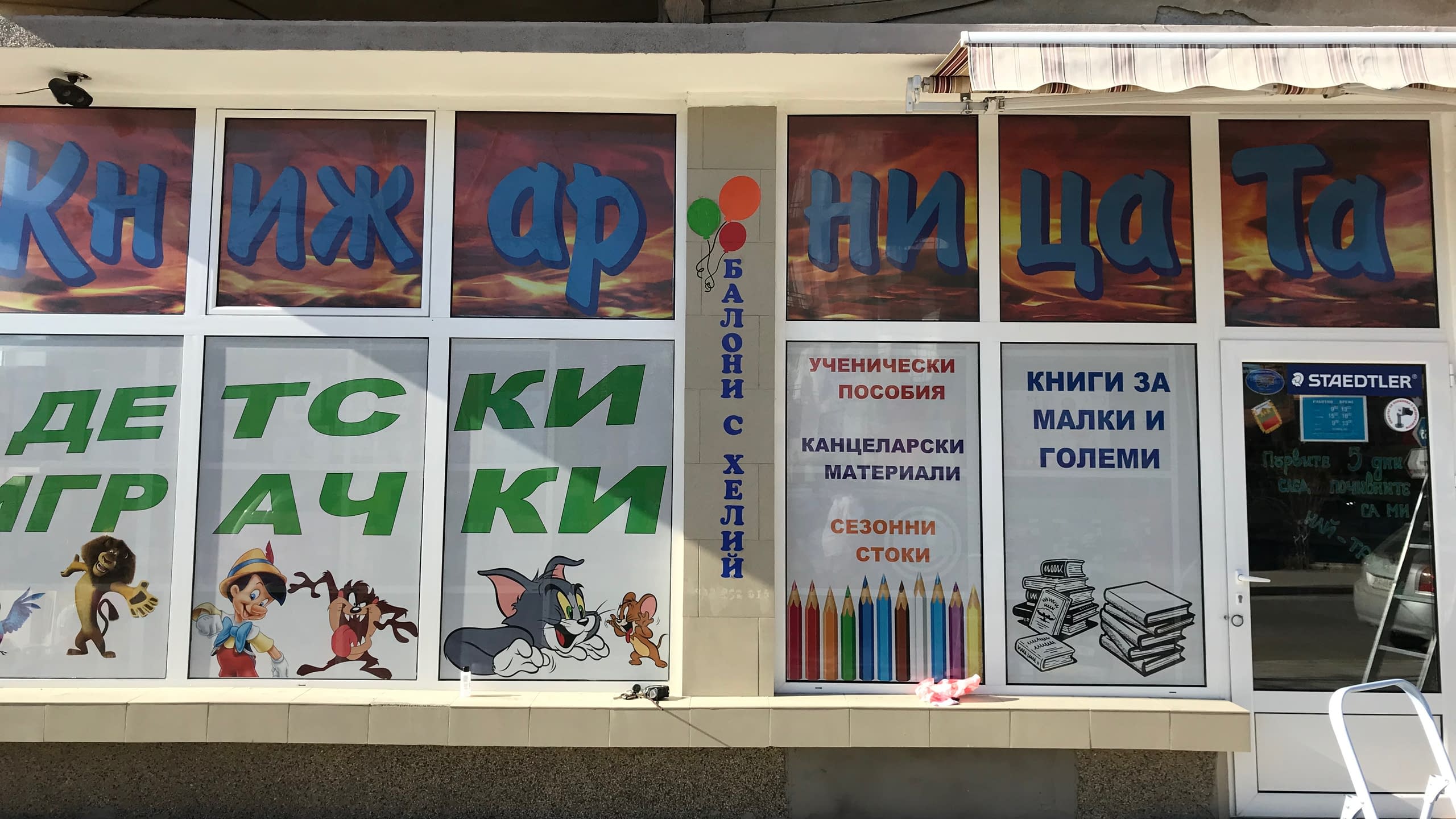 Цветно брандирана витрина на книжарница и магазин за детски играчки с перфо фолио (фолио на дупки) с анимационни герои.