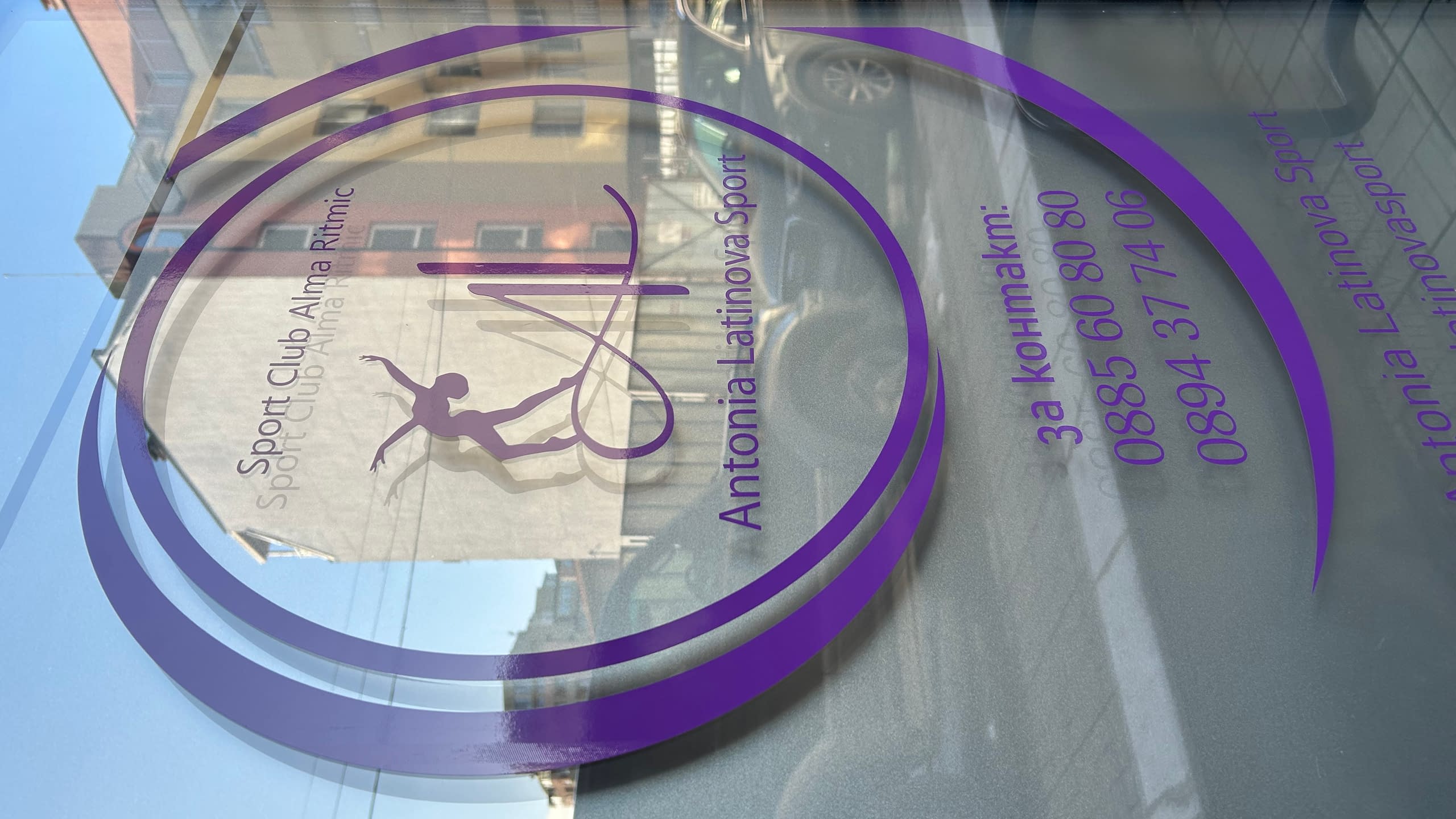 Стъклена витрина, фолирана със стикер от лилаво изрязано фолио с логото и контактите на спортен клуб "Antonia Latinova Sport".