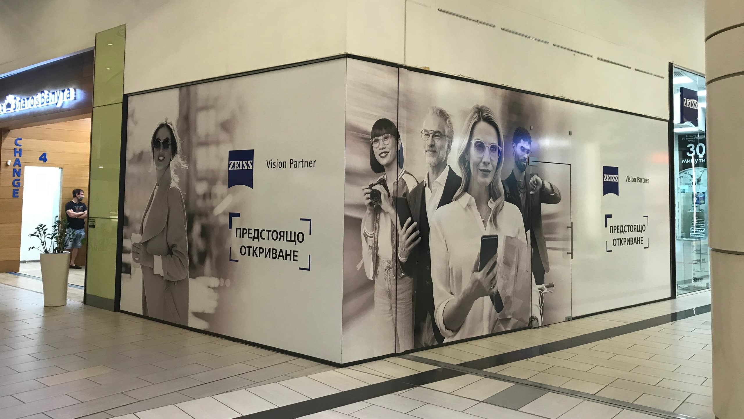 Цялостно фолиране на витрини на бъдещ магазин на "ZEISS Vision Partner" в мол с рекламни пана с надпис "Предстоящо откриване".