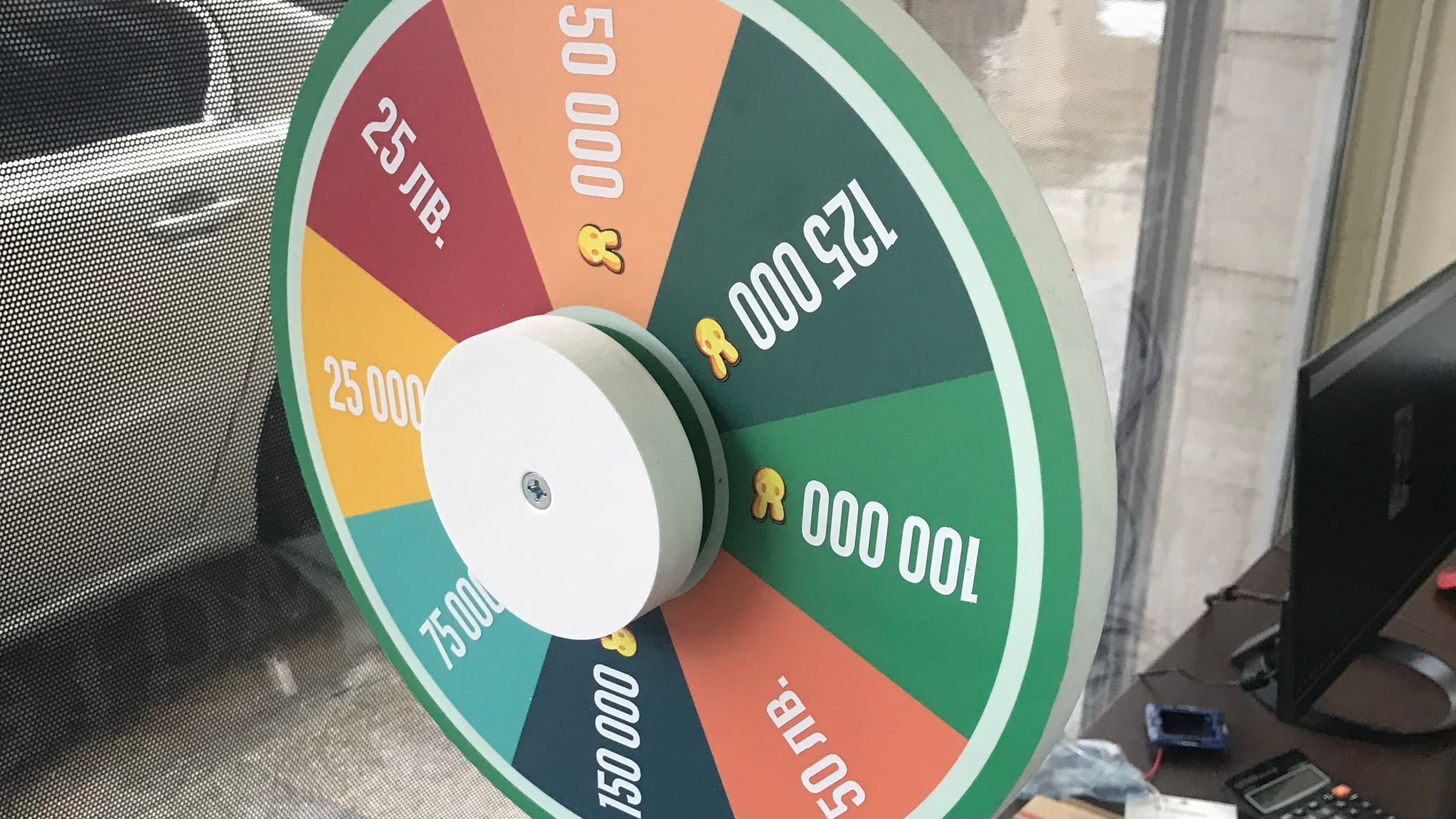 Цветно колело на късмета със сектори, показващи големи парични награди в лева, като "25 лв.", "50 000" и "125 000".