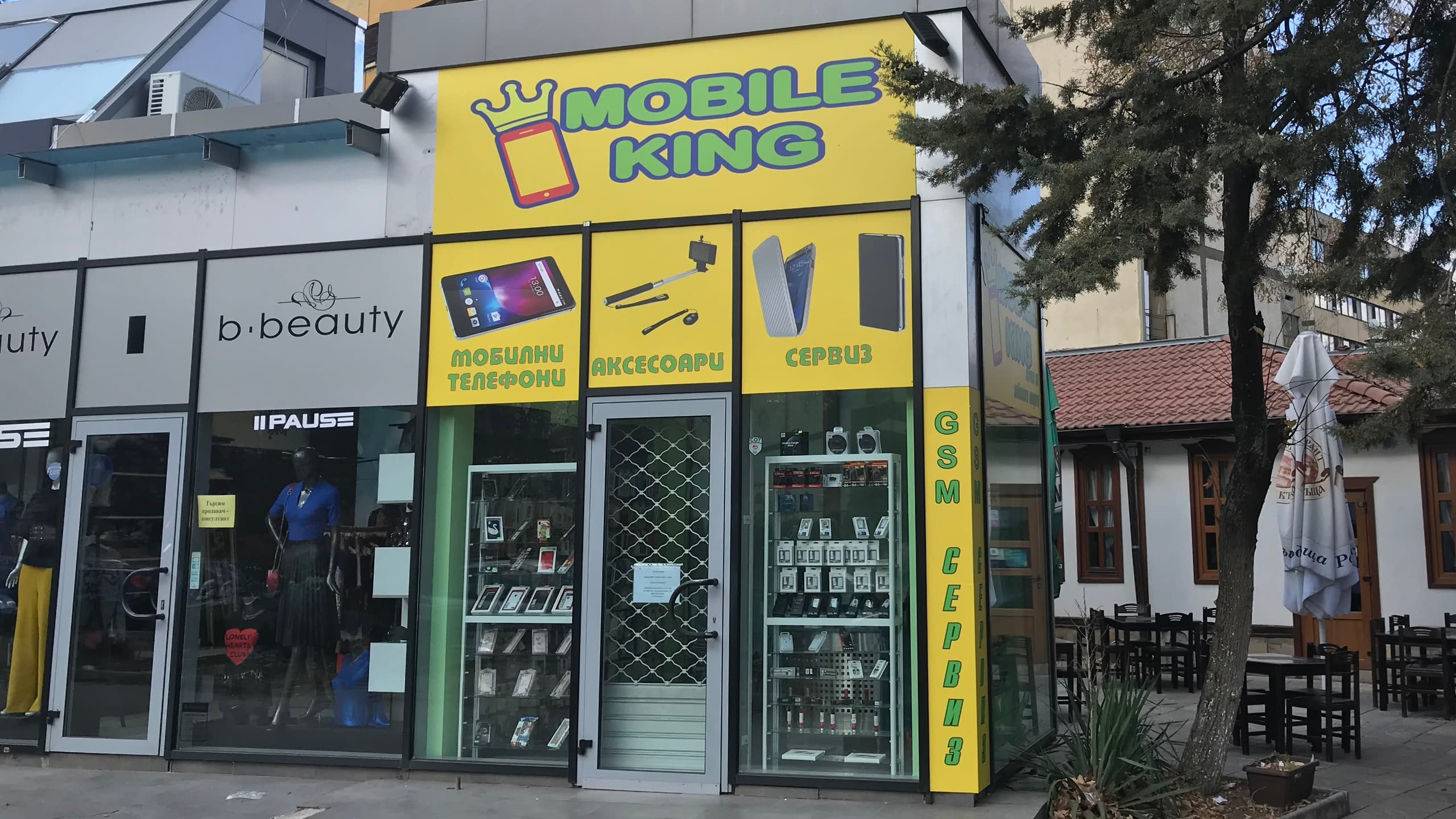 Цялостно брандирана с жълто рекламно фолио витрина на магазин за мобилни телефони и аксесоари "Mobile King".