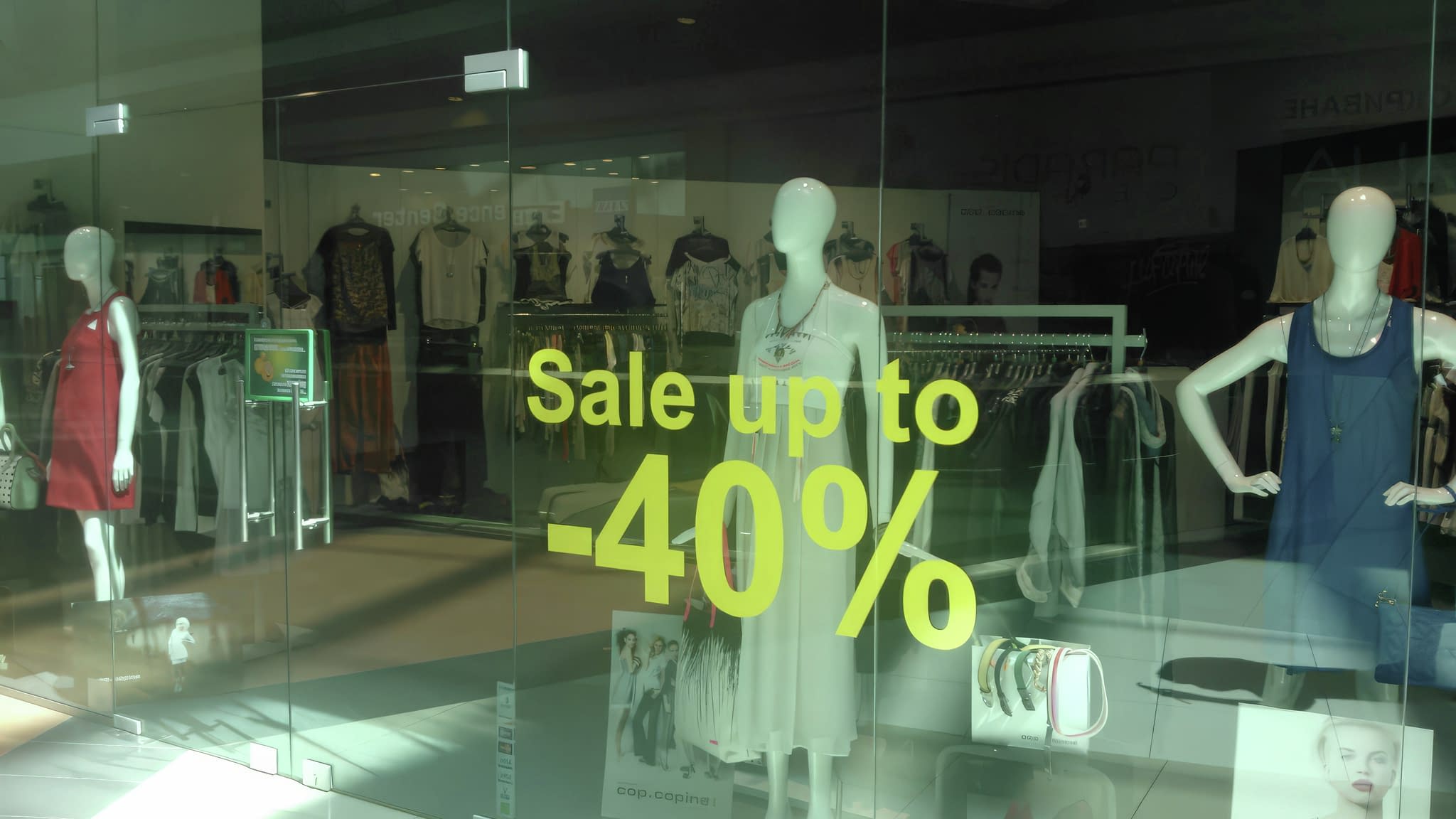 Монтаж на прозрачно фолио с рекламно послание на витрина на магазин – надпис Sale up to -40%.