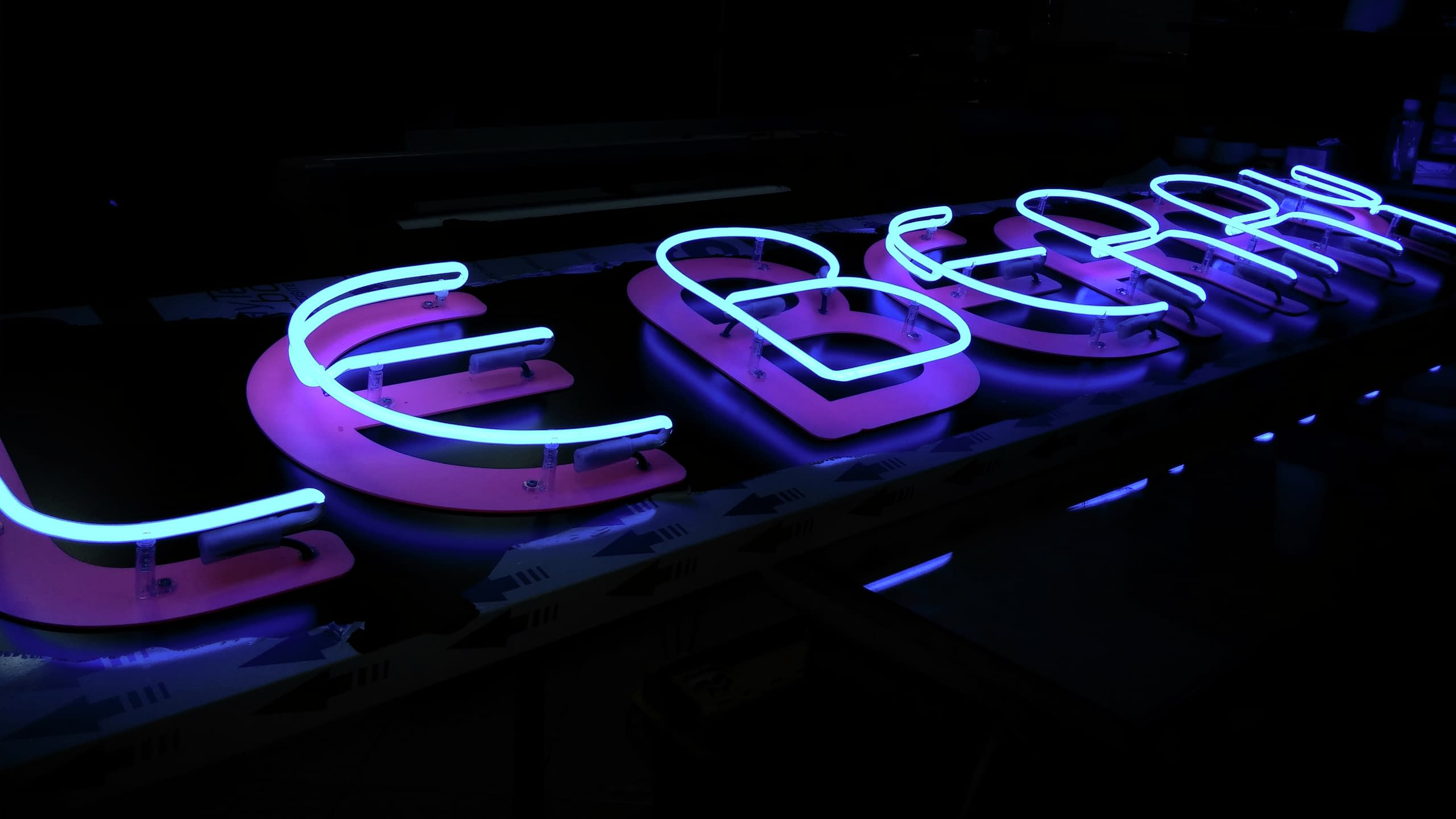 Изработка на неонова реклама "Le Berry" - светещи в синьо неонови тръби върху розови обемни букви.