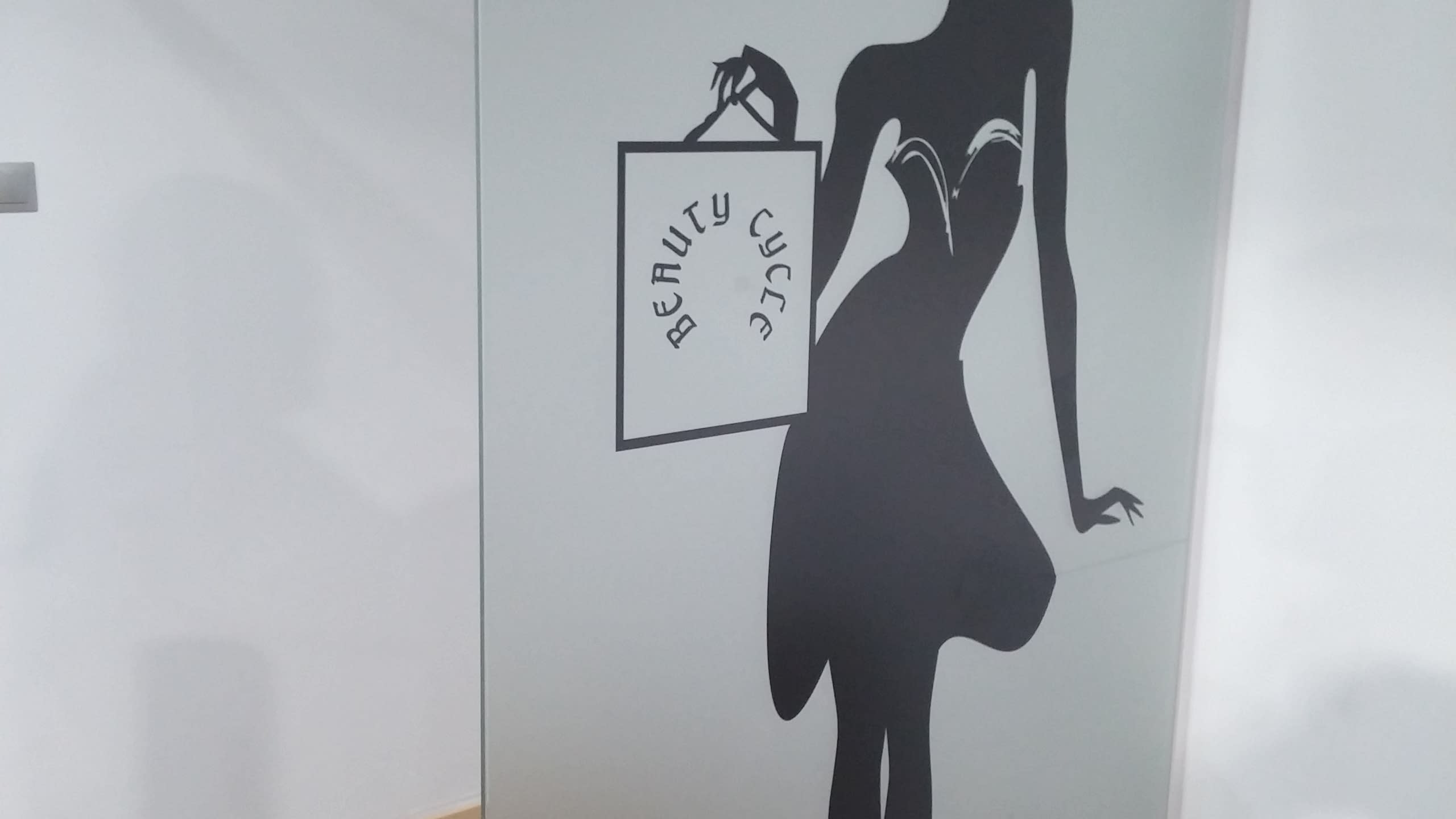 Графичен силует на жена в рокля, която държи в ръка пазарска чанта с надпис „Beauty Cycle“.