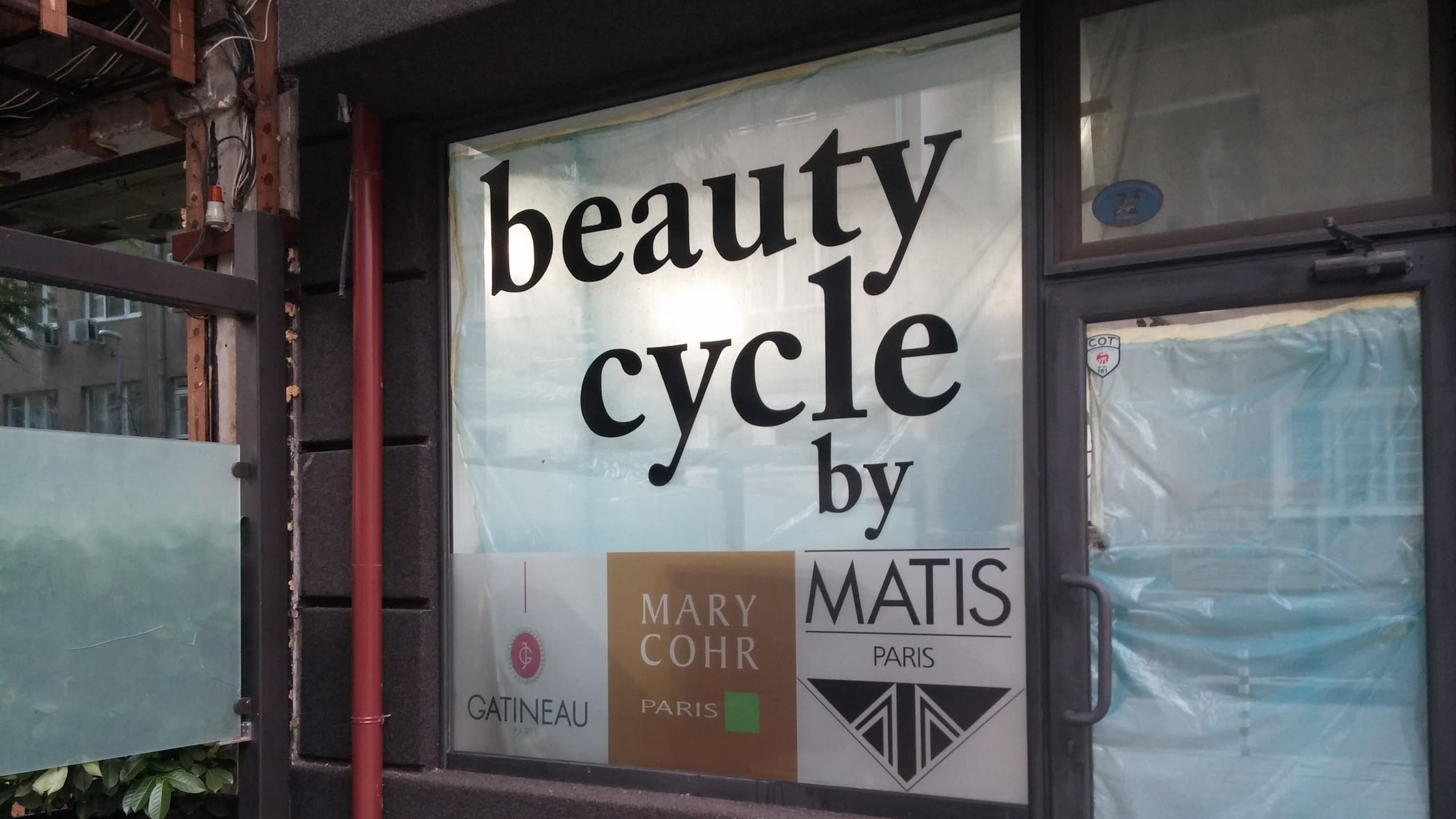 Челен изглед към брандирана витрина и входна врата, покрита със защитно фолио.