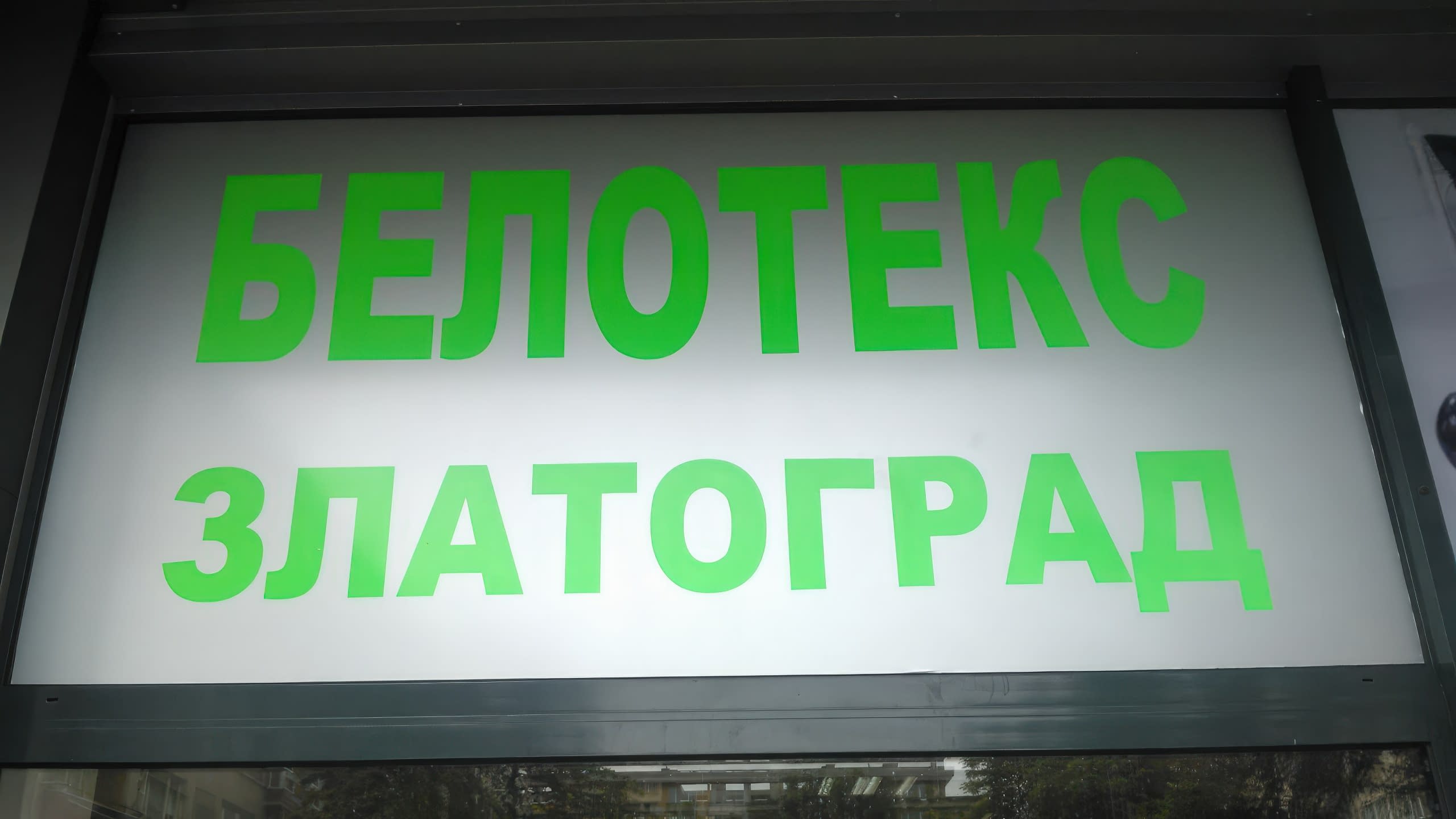 Близък план на зелен надпис "Белотекс Златоград", изработен от фолио върху матирана повърхност.