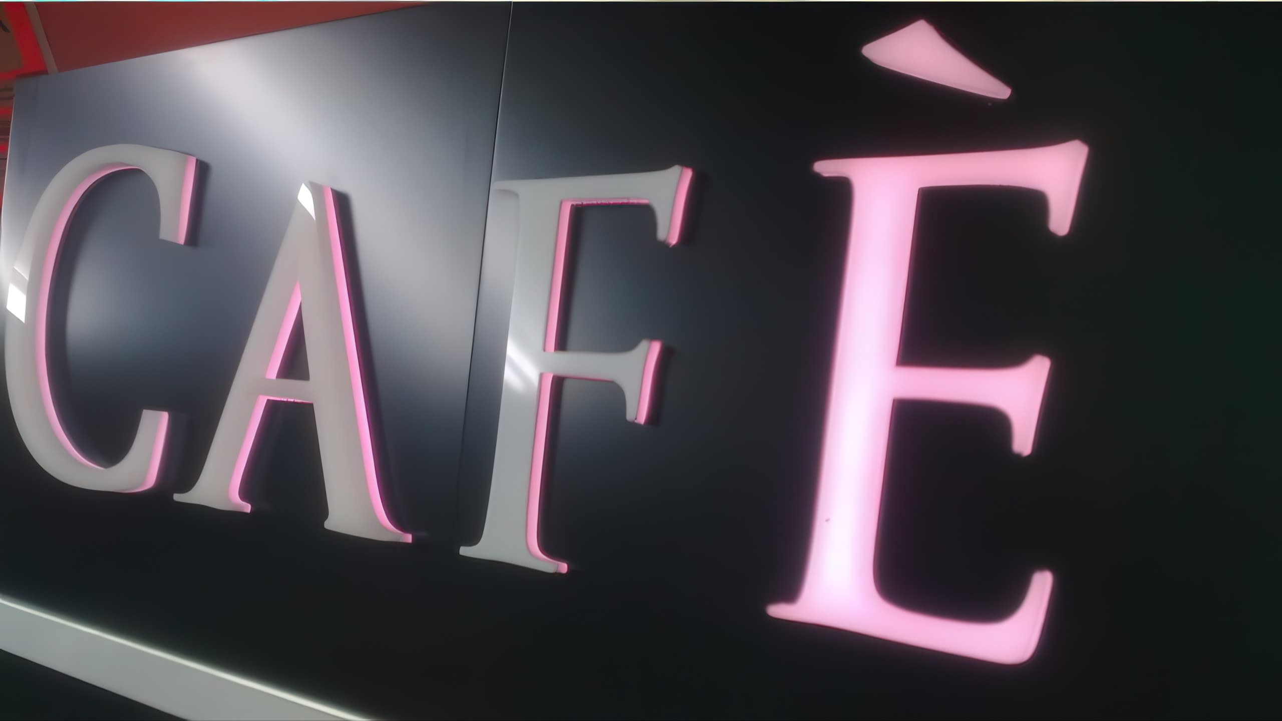 Табела с надпис „CAFÈ“ с бяло лице на буквите и нежна розова подсветка.