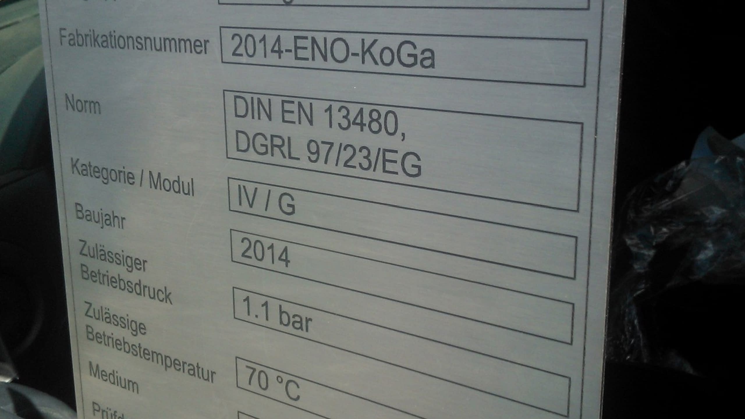 Гравирана метална табелка с технически данни на немски език за промишлено оборудване.