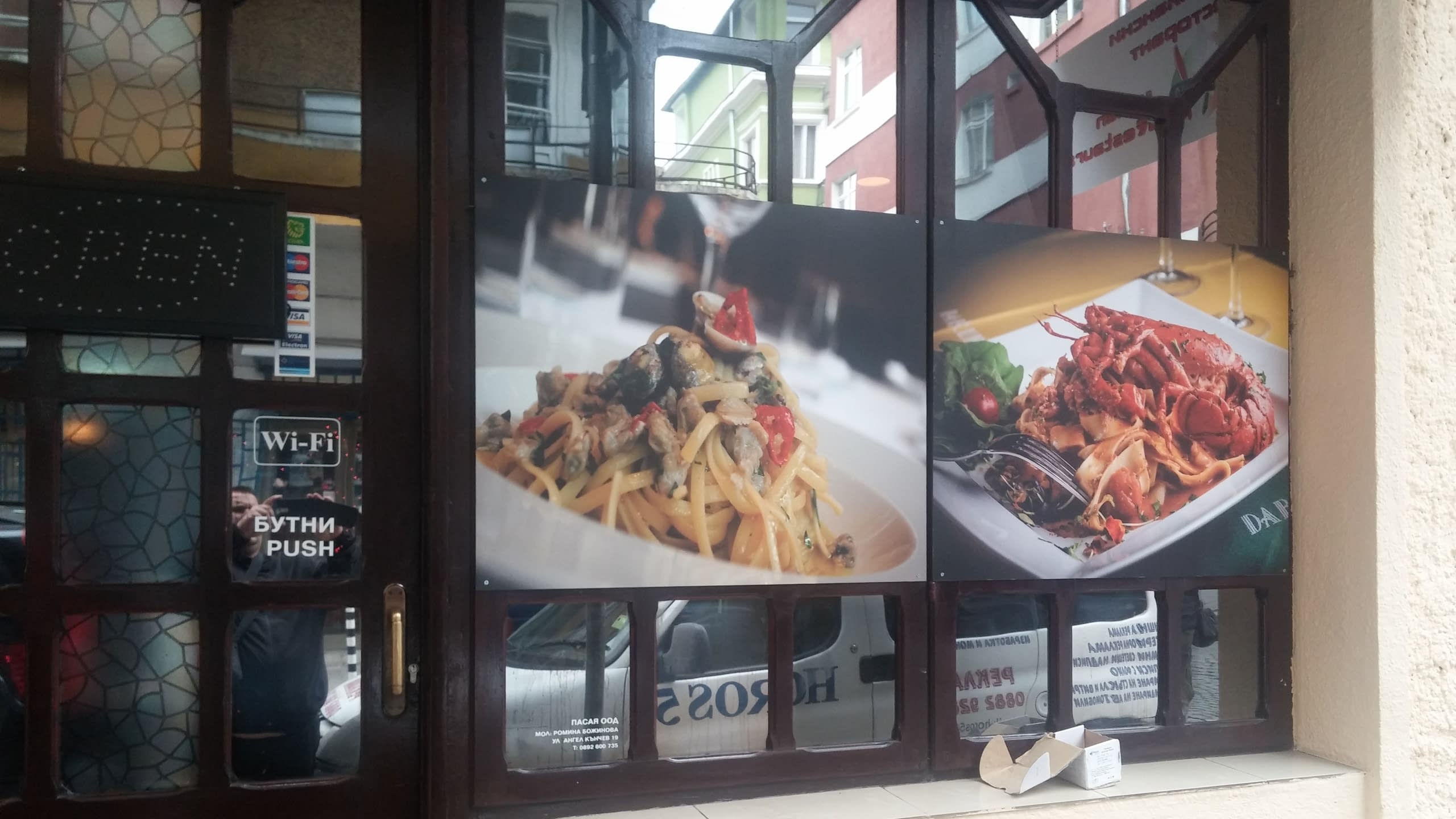 Близък план на две снимки на витрина - паста с миди и паста с омар.