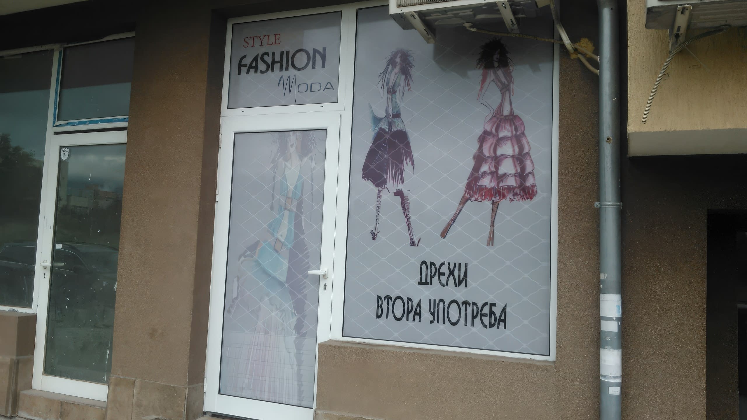 Вход и витрина на магазин, брандирани с фолио с артистични модни фигури.