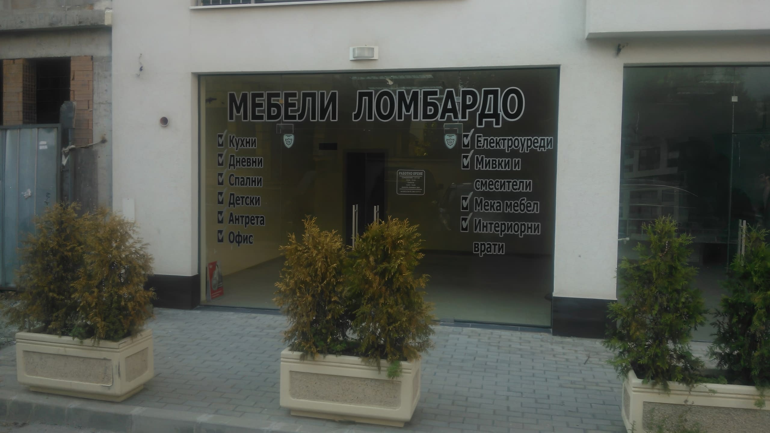 Вход на магазин "Мебели Ломбардо", декориран със стикери, които представят продуктовите категории.