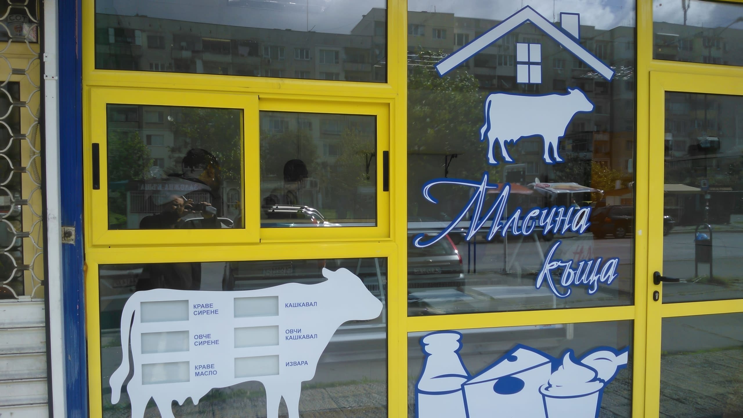 Близък план на стикер на крава, превърнат в табло за цени на млечни продукти.