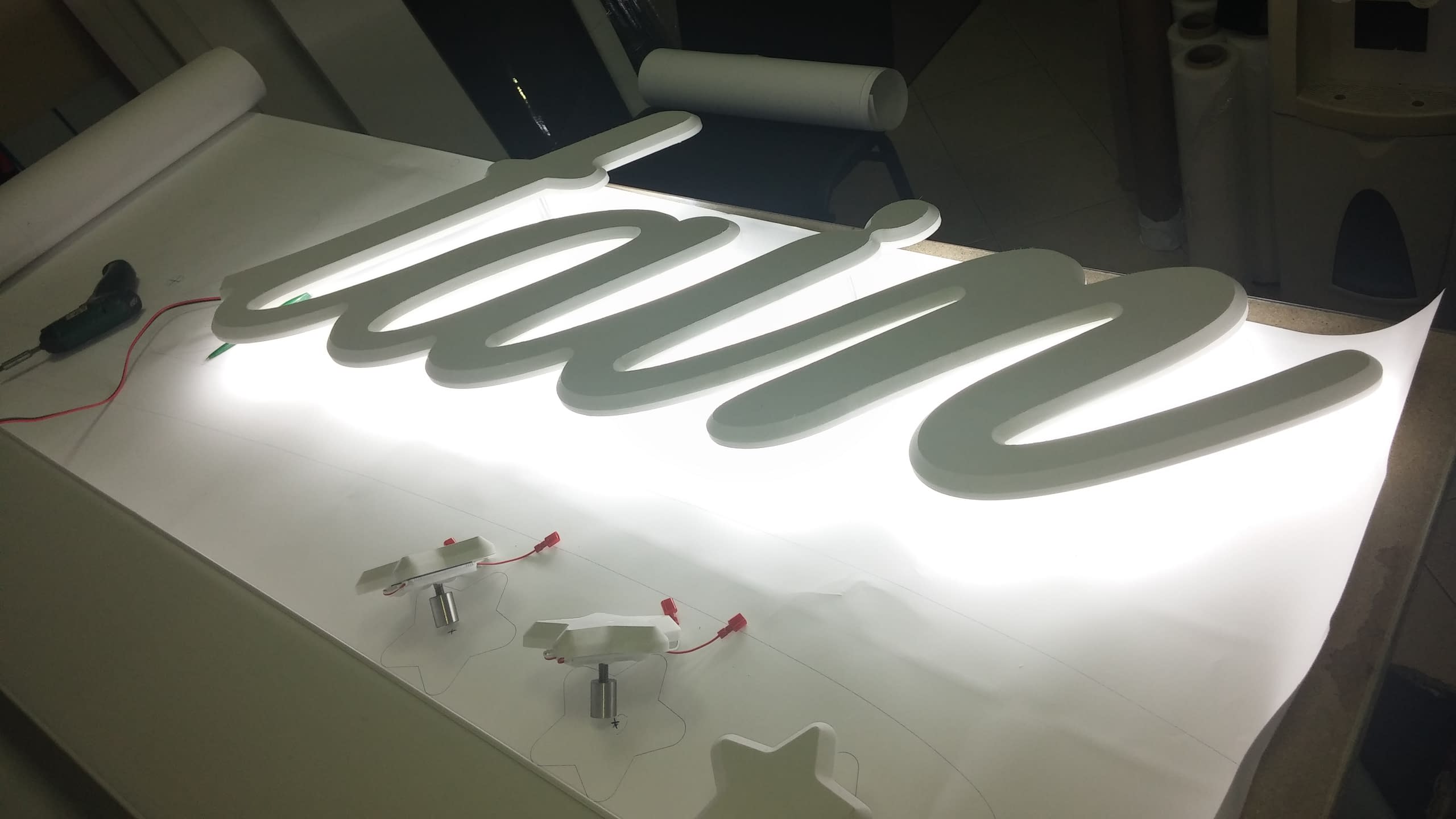 Тестване на задното осветление на бели обемни букви с надпис "Mountain" в ателие.