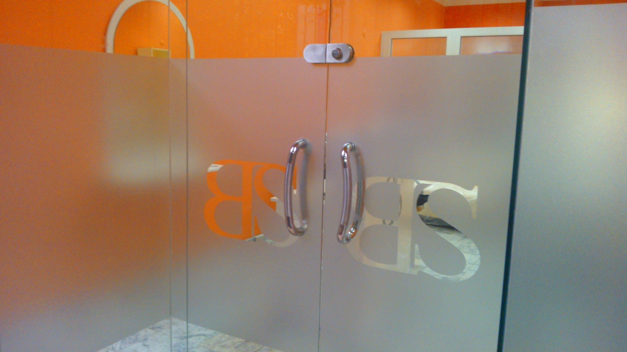 Матирано фолио, апликирано върху стъклена преграда в офис, осигуряващо уединение.