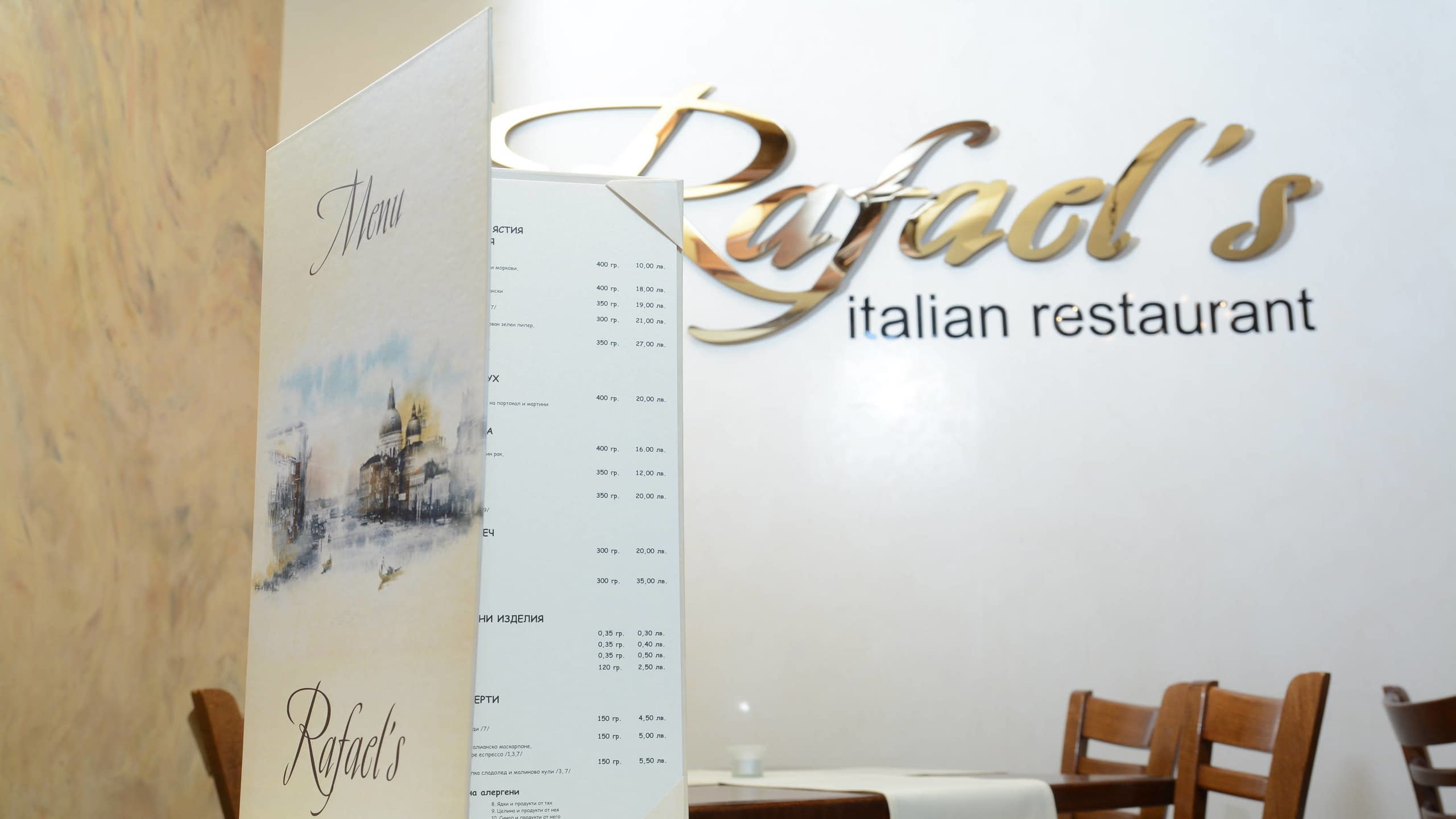Меню на маса в ресторант, с фирмено лого на стената във фона.
