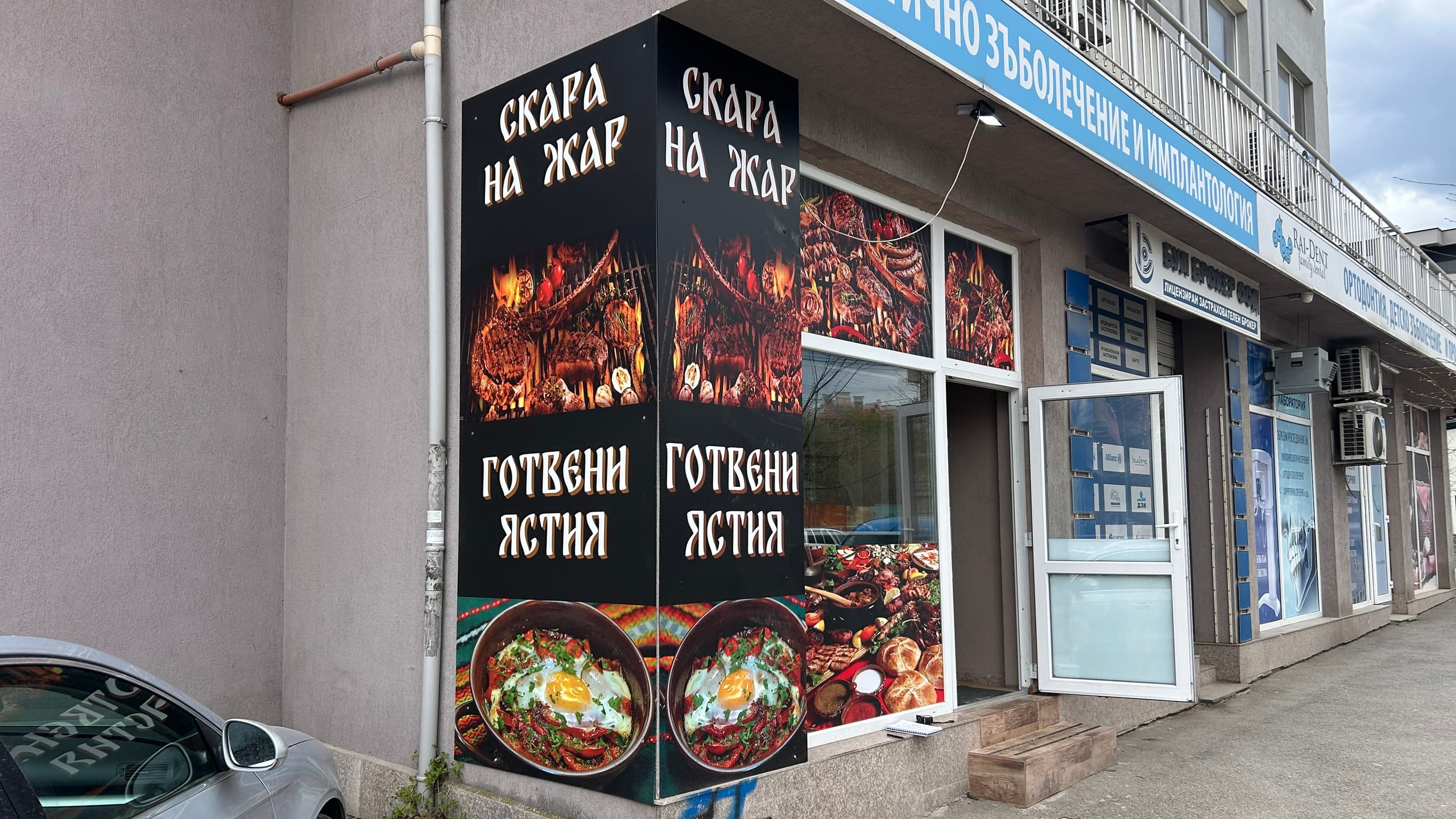 Фасада на ресторант, изцяло брандирана с рекламно фолио с апетитни снимки на скара на жар и готвени ястия.