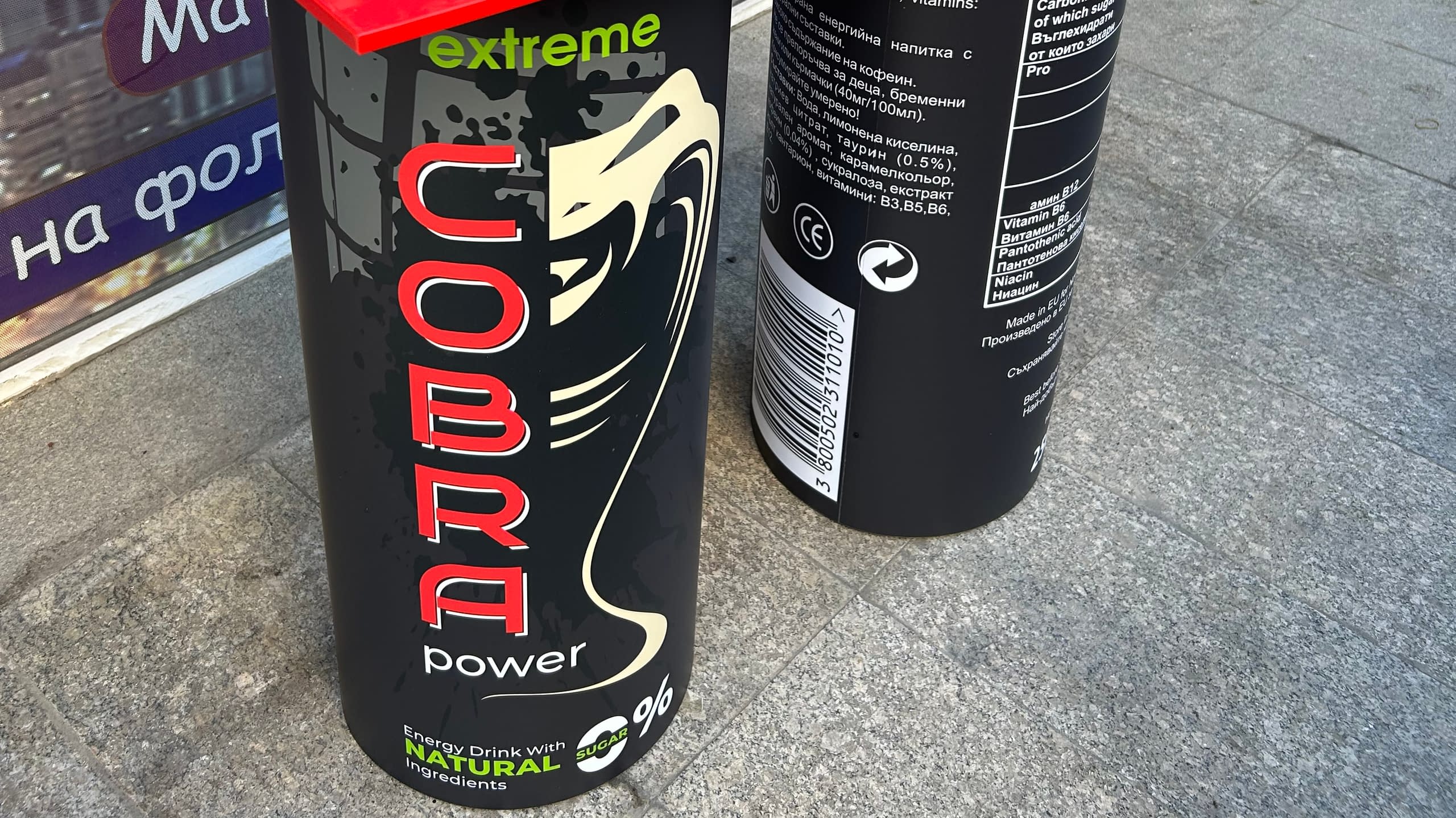 Близък план на брандирани кенове с енергийна напитка "Cobra extreme power", за които изработваме рекламни материали и стелажи.