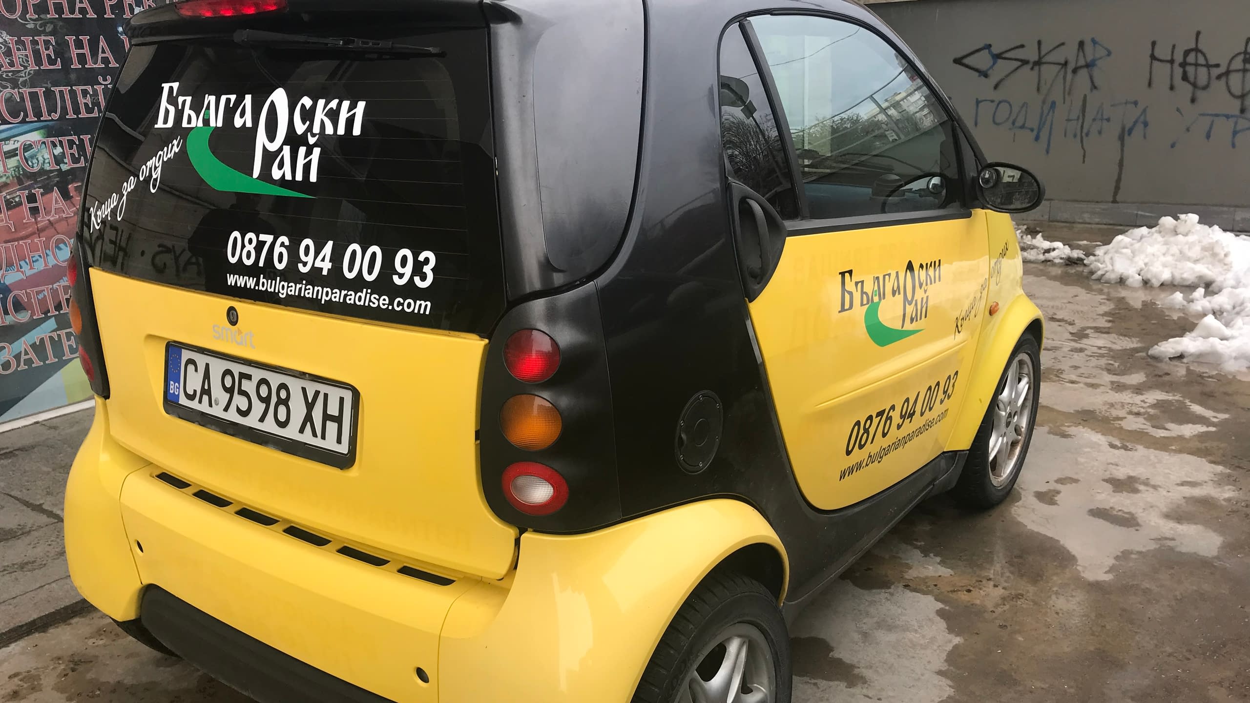 Жълт автомобил Smart, брандиран с рекламно фолио на "Български Рай". Използвано е рязано фолио за логото, телефонния номер и уебсайта.