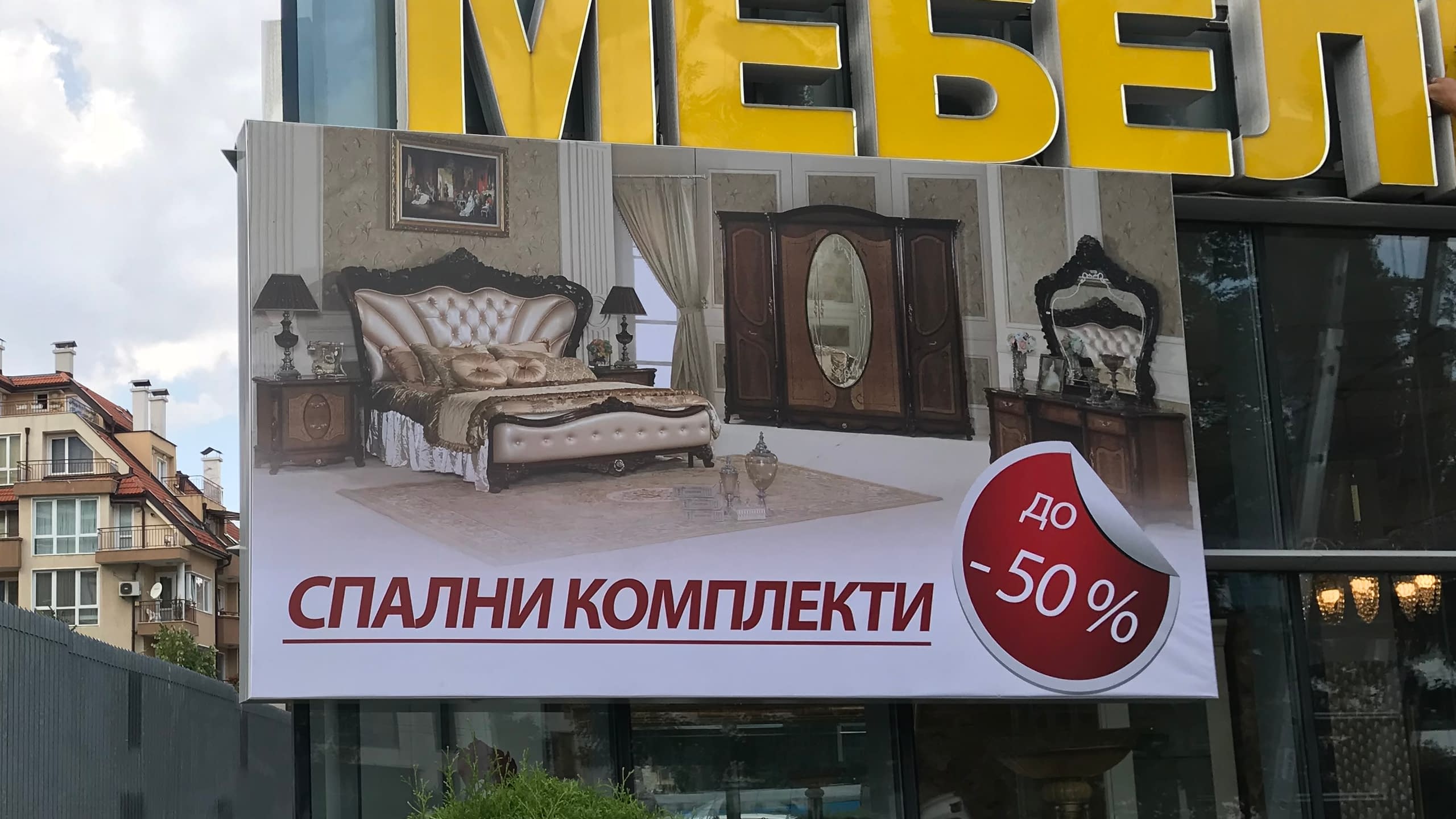 Рекламно пано от винил на магазин за мебели, рекламиращо спални комплекти с отстъпка до 50 процента.