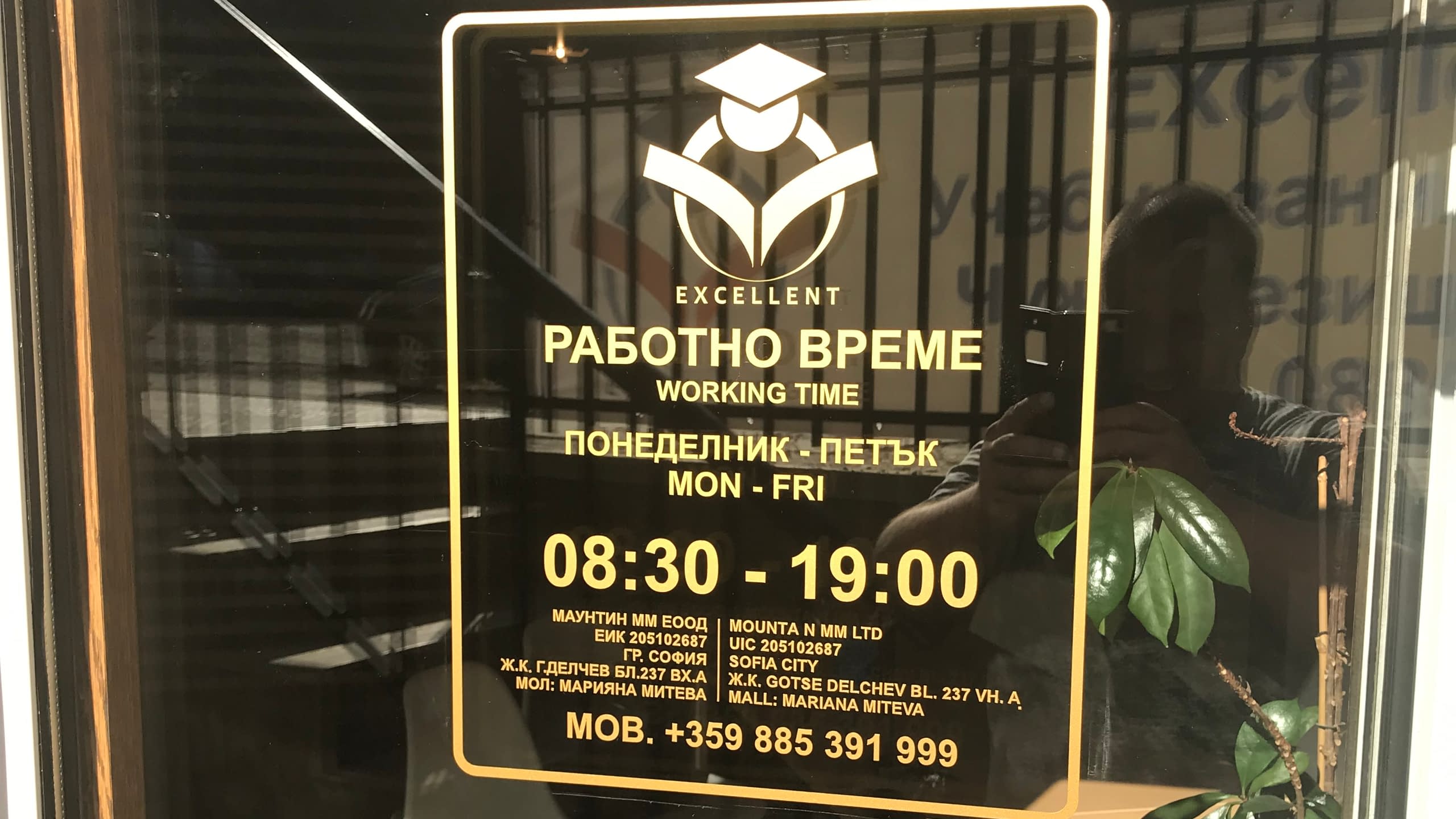 Стикер с работно време и фирмени данни на "Маунтин ММ ЕООД", изрязан от светло фолио и залепен на стъклена врата на офис.