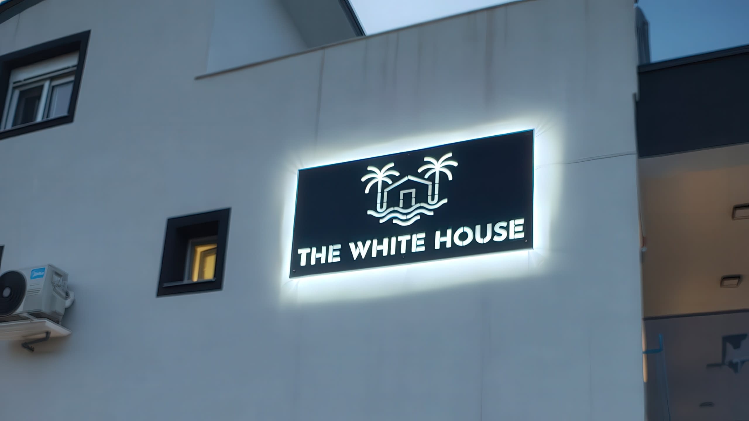 Модерна външна светеща табела за хотел "THE WHITE HOUSE", изработена с контражурно осветление и светещи надписи, изрязани в черния панел.