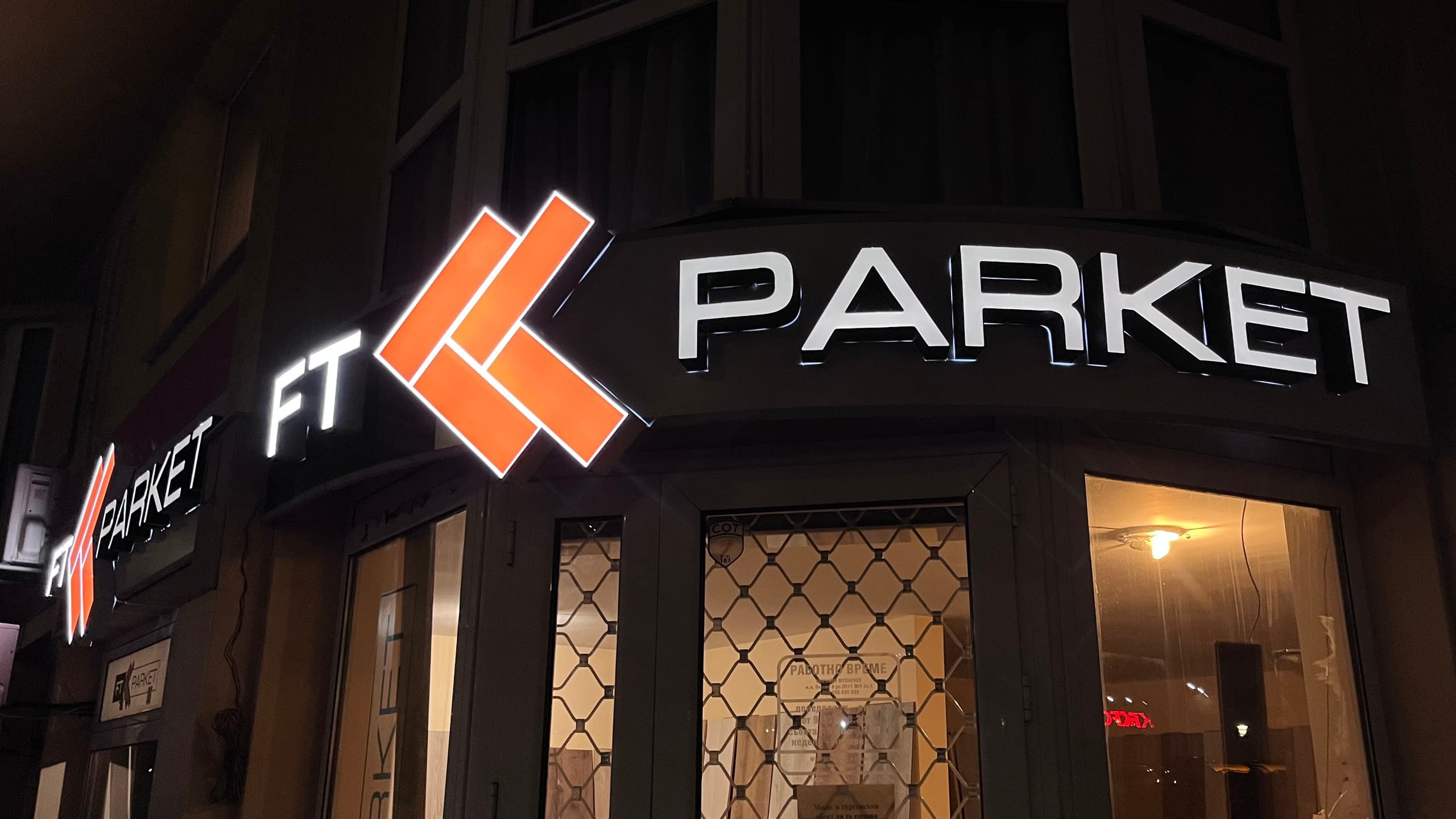 Ъглова светлинна реклама за магазин "FT Parket" с обемни светещи букви и оранжево светещо лого.