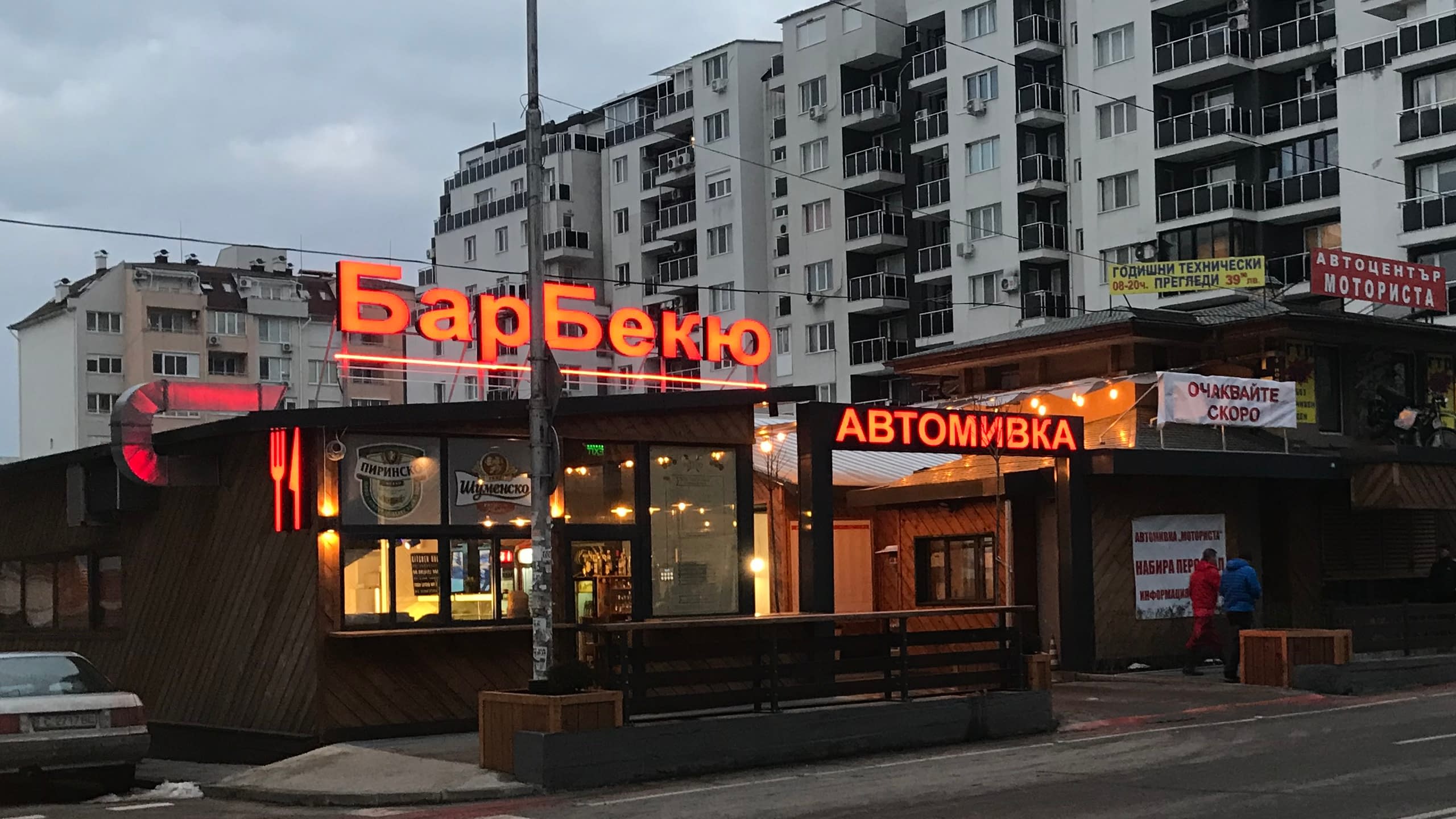 Големи външни светещи обемни букви с надпис "БарБекю" в червен цвят, монтирани на покрива на заведение.