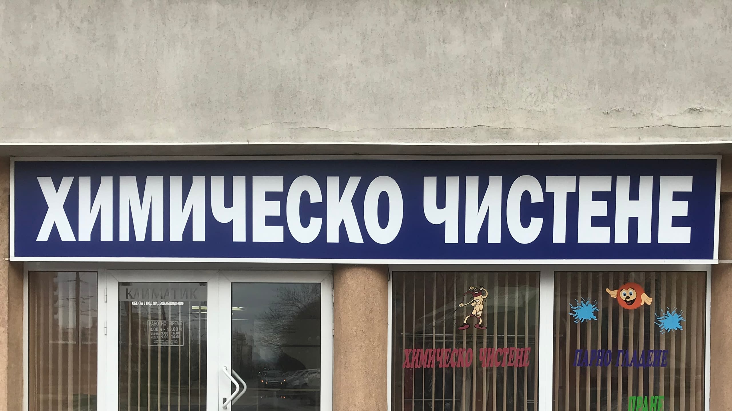 Голяма външна несветеща табела за "Химическо чистене". Синя правоъгълна табела с големи бели букви за максимална видимост.