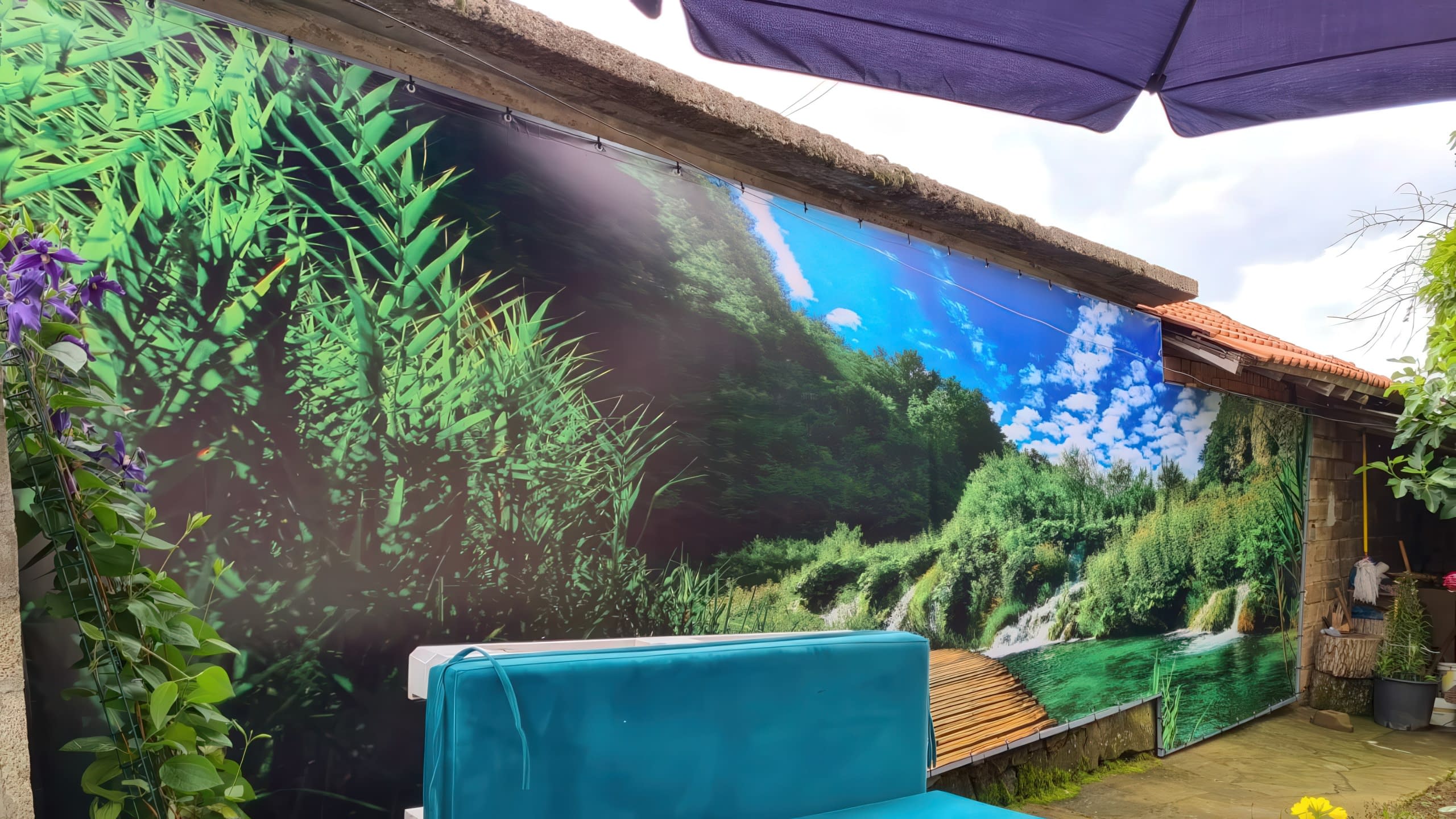 Декоративни винилови пана с фотореалистичен печат на зелен горски пейзаж, използвани за украса на двор.